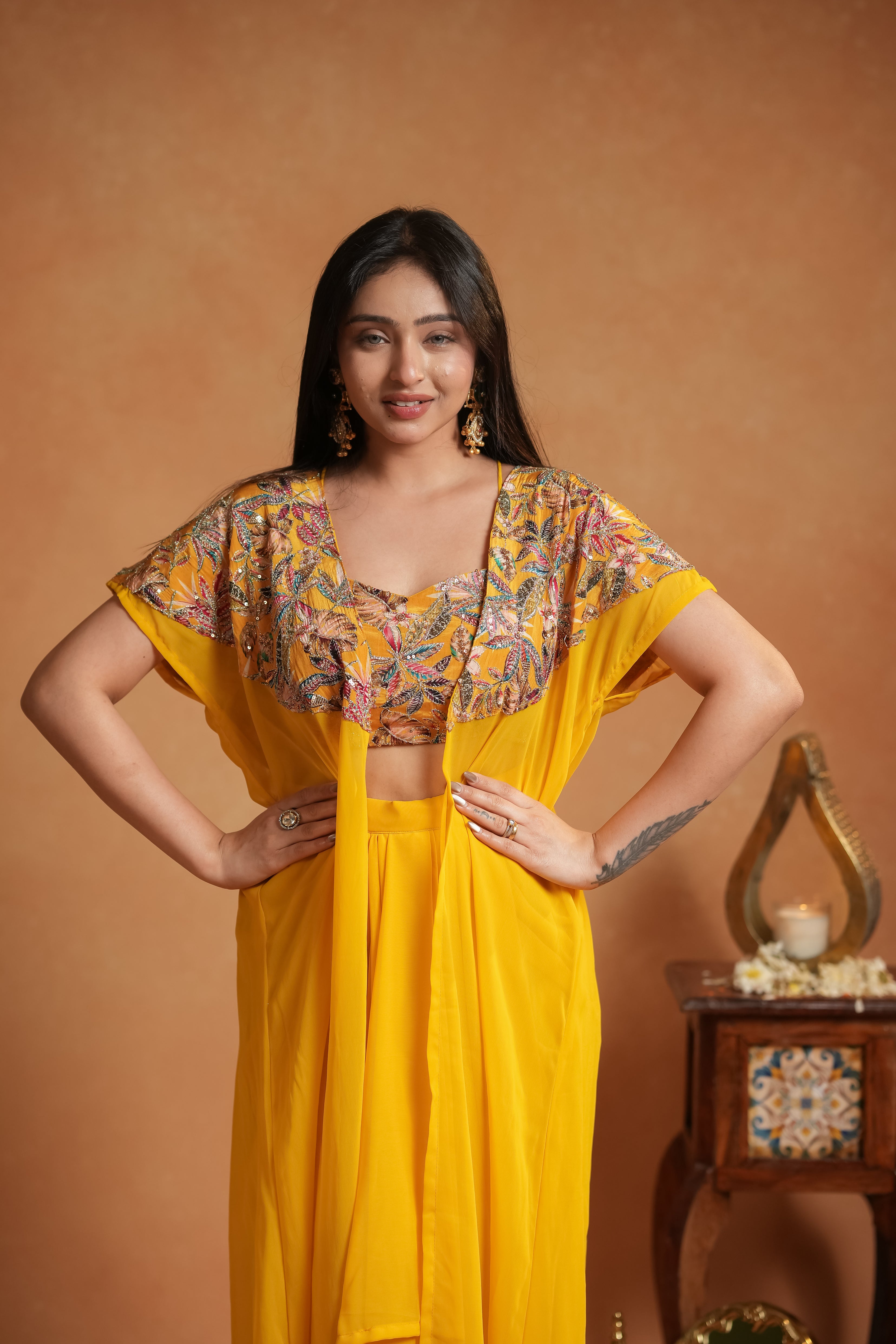 Woman wearing a yellow outfit with floral patterns on a brown background
